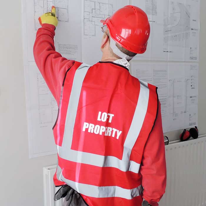A Loft Property Carpenter Looking at Building Plans